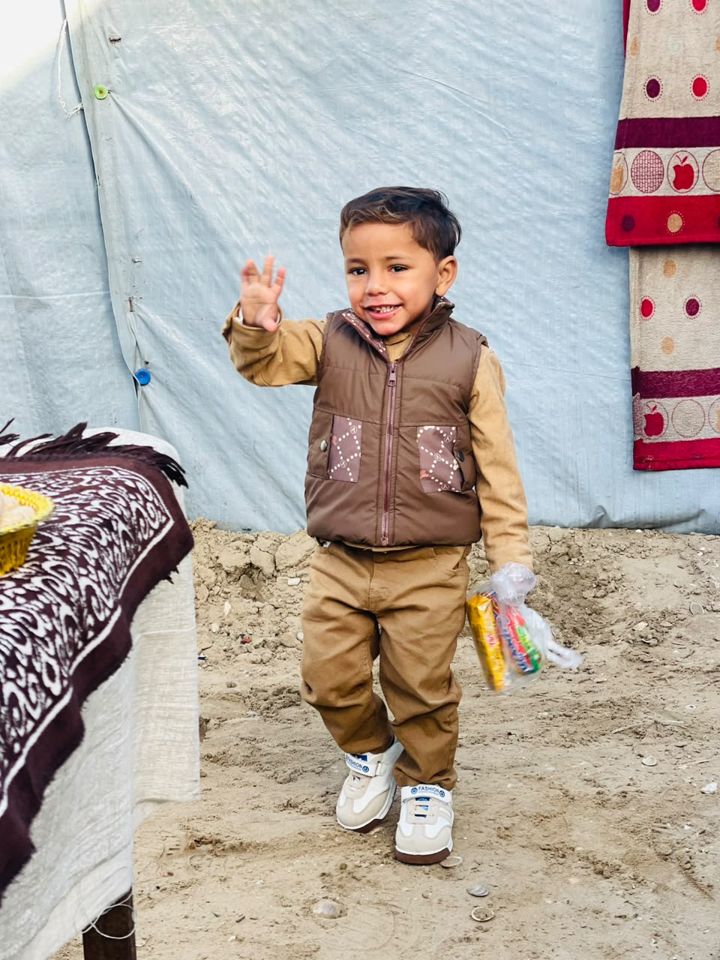 A boy waving at the camera